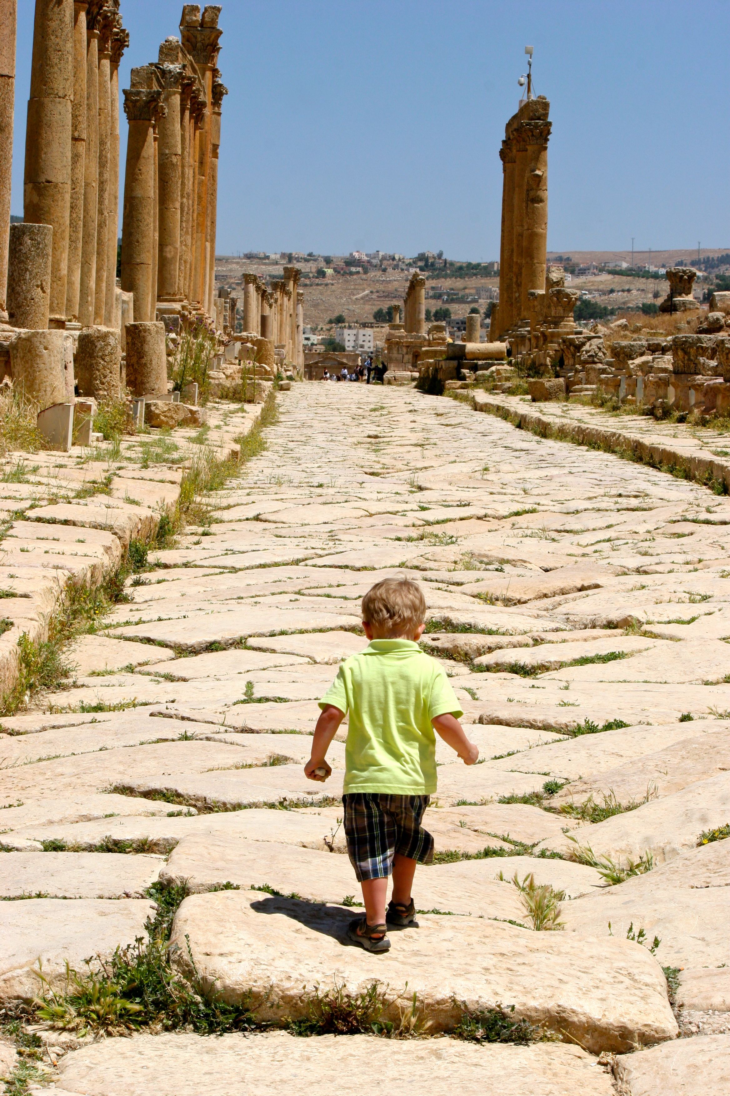 young child walking a Roman road in Jerash, Jordan