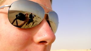 Man wearing sunglasses reflecting the Tunisian desert