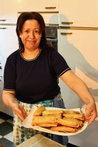 Tunisian woman displaying a tray of egg briks