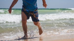 Boy running along the shoreline