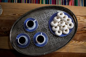 View from above of Tunisian kaak warqa and Turkish coffee on a traditional serving plate